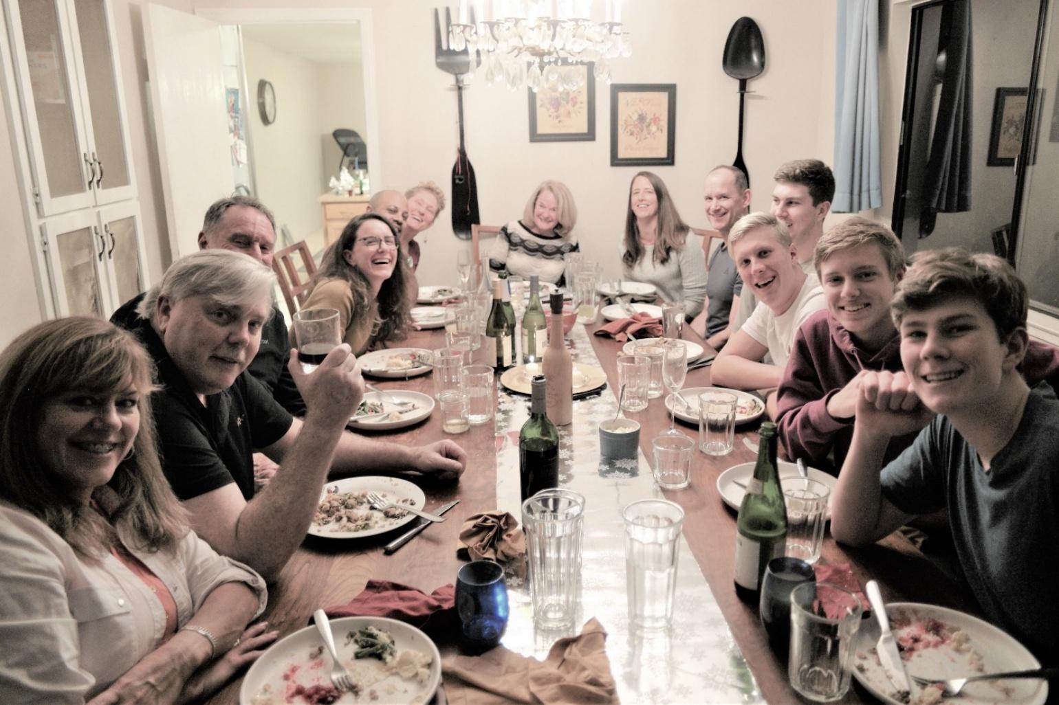 The Strand family gathered around a large dinner table, laughing and celebrating together — the kind of holiday gathering Laurel shared with them for over 30 years.